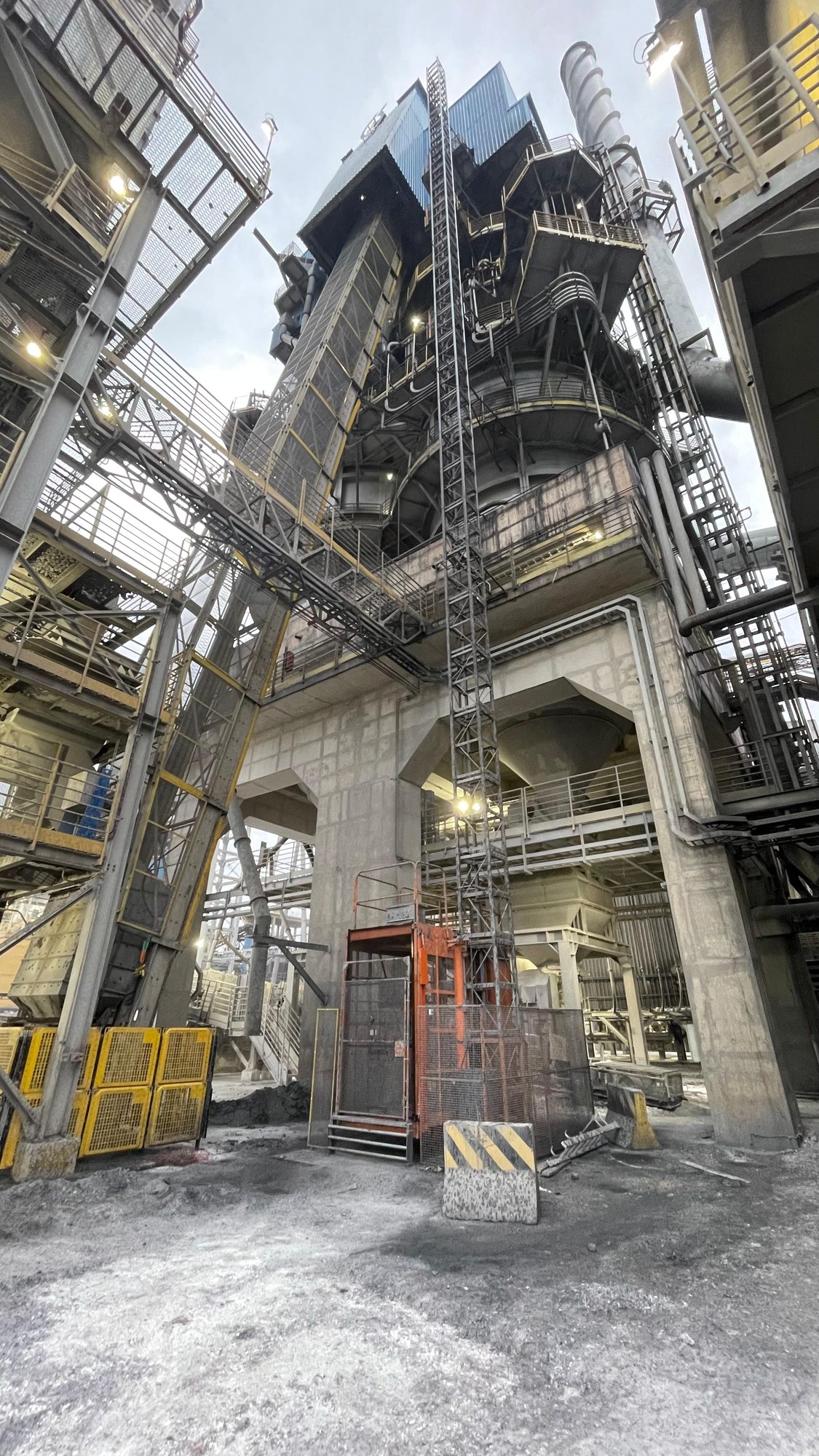 Elevador de cremalheira instalado em estrutura industrial, com torre e cabina de acesso.