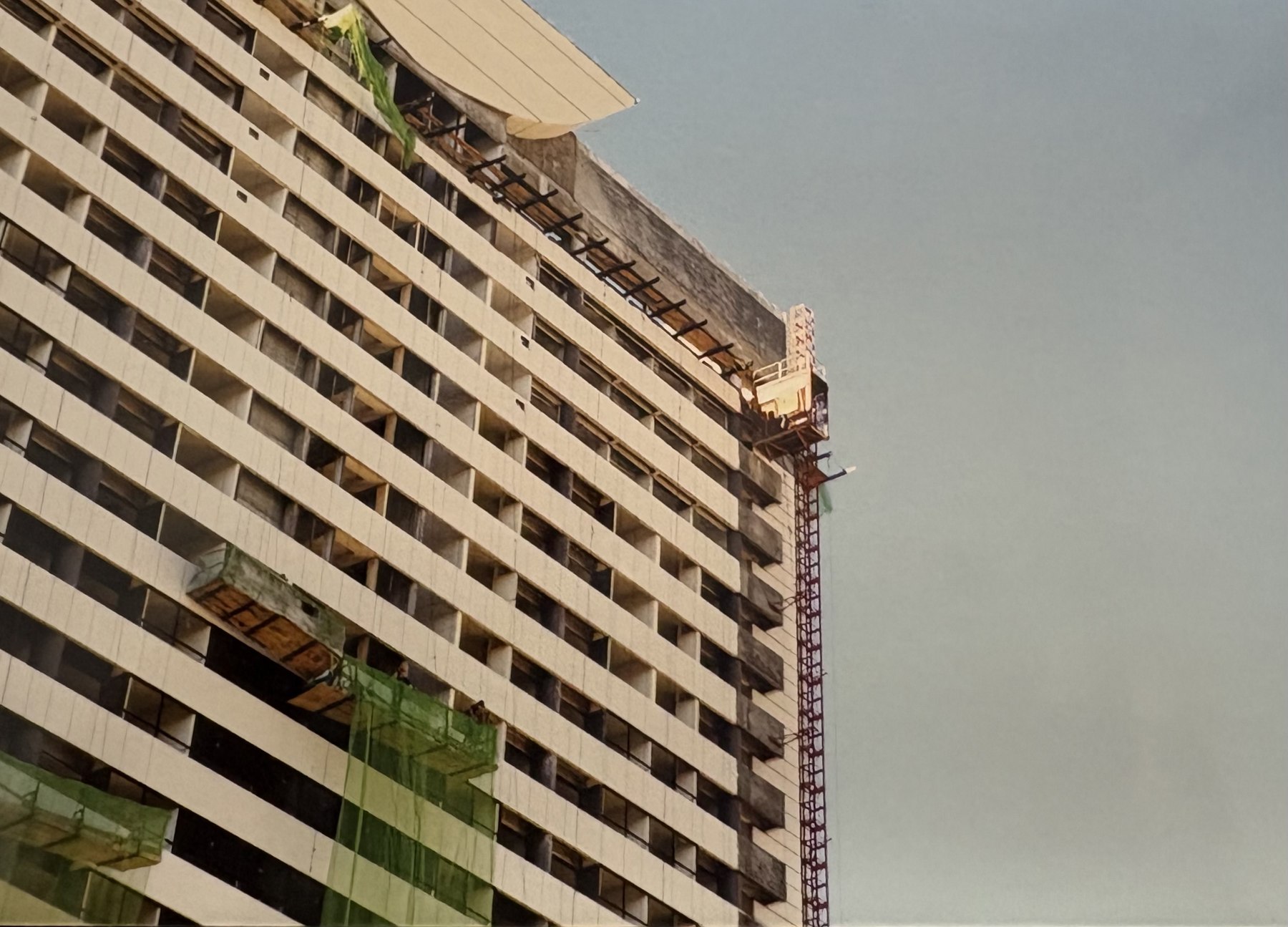 Elevador instalado en el lateral de un edificio, en una fotografía histórica.