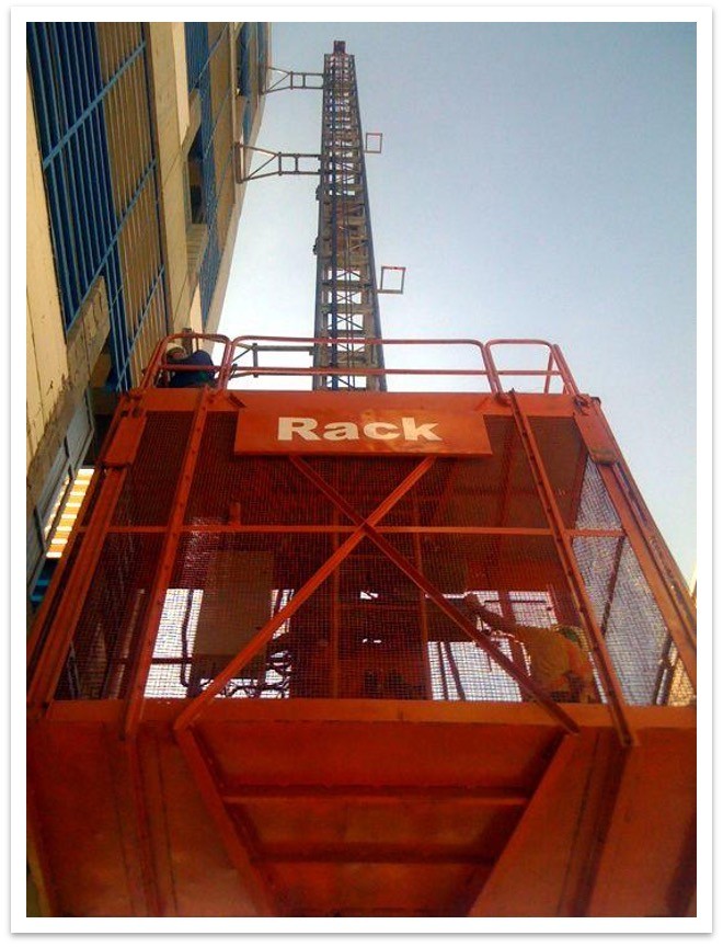 Elevador de cremallera con la marca Rack en la cabina y torre instalada junto al edificio.