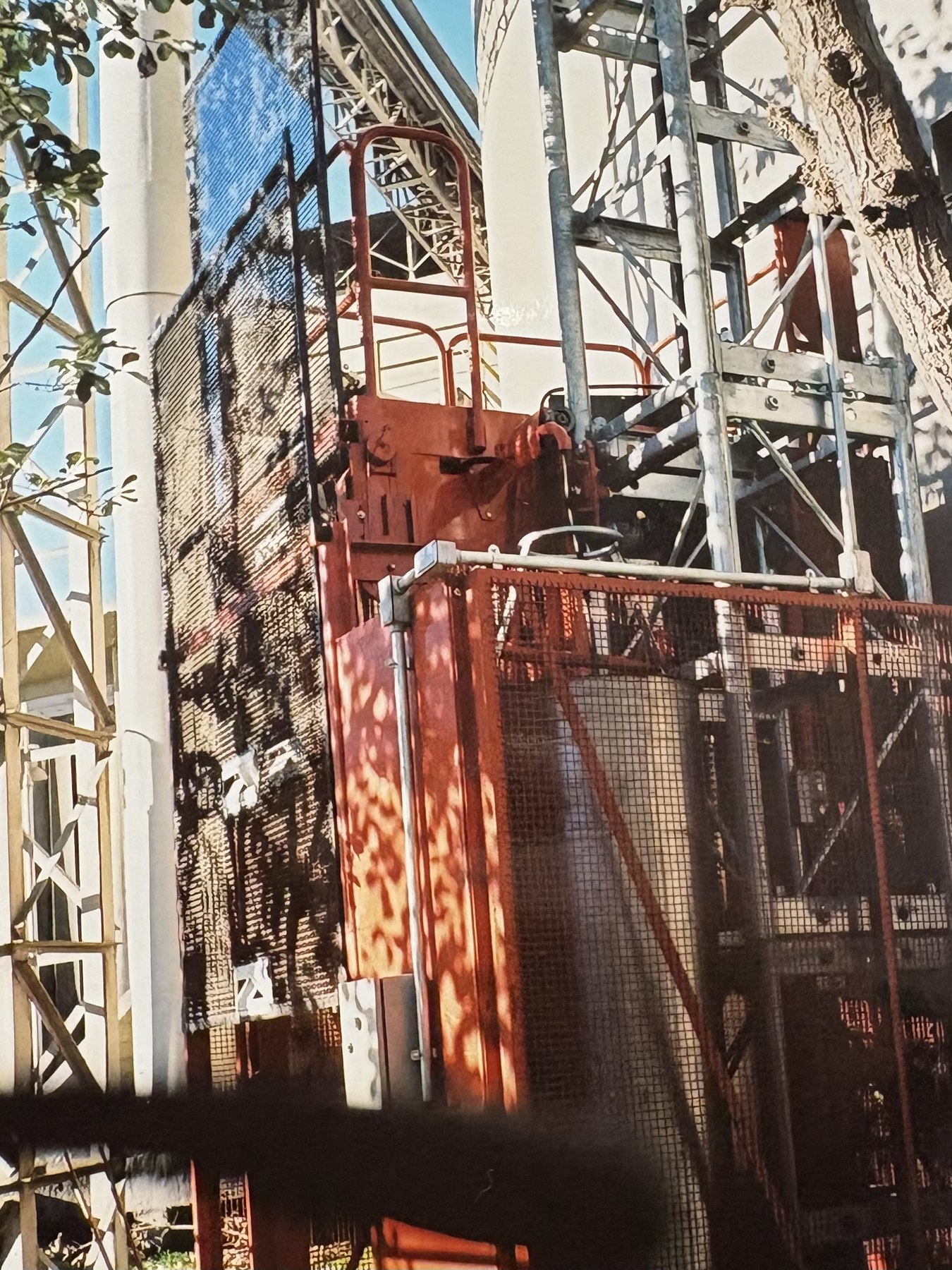 Elevador y torre instalados junto a un edificio en construcción.